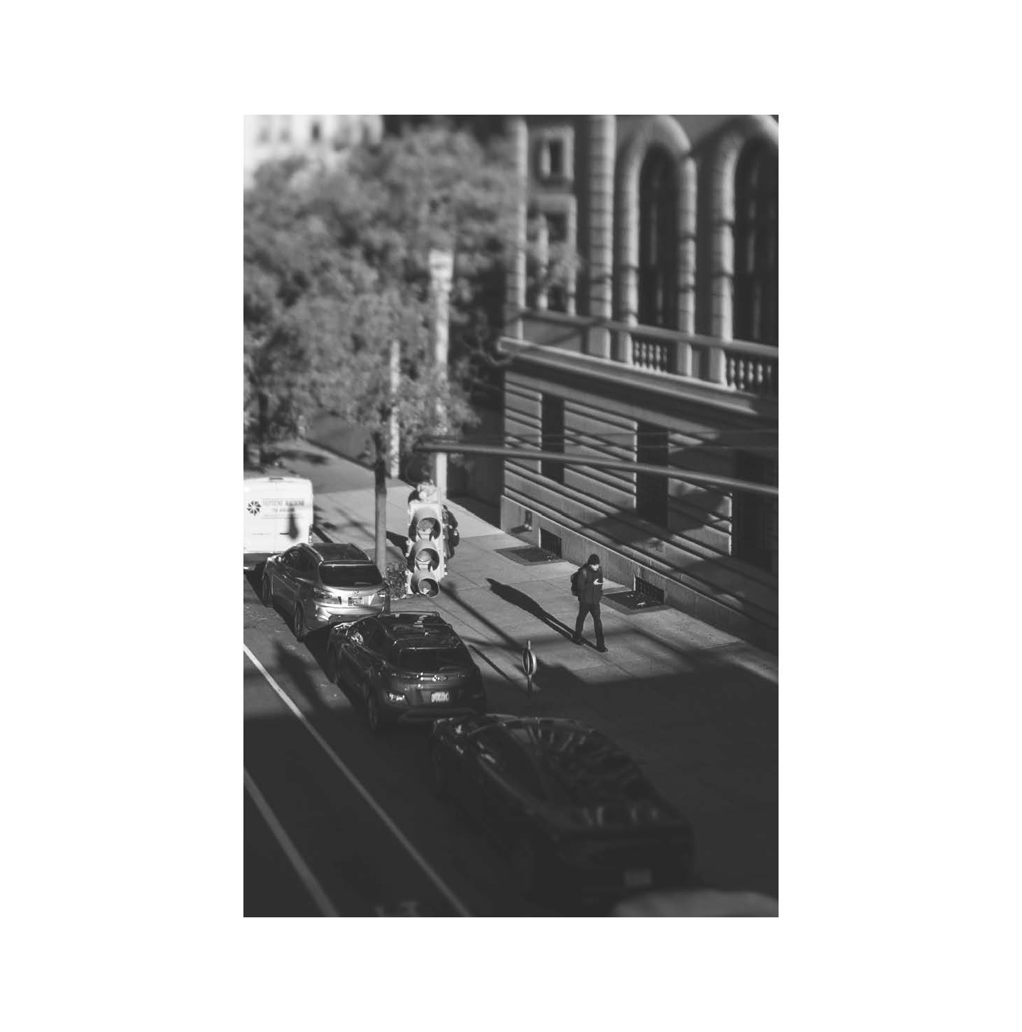 People and parked cars along a sidewalk