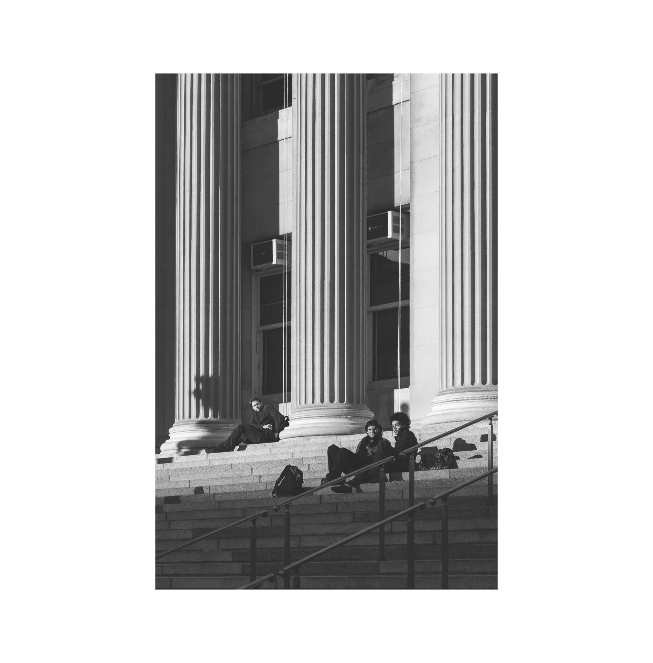 People resting beside monumental columns